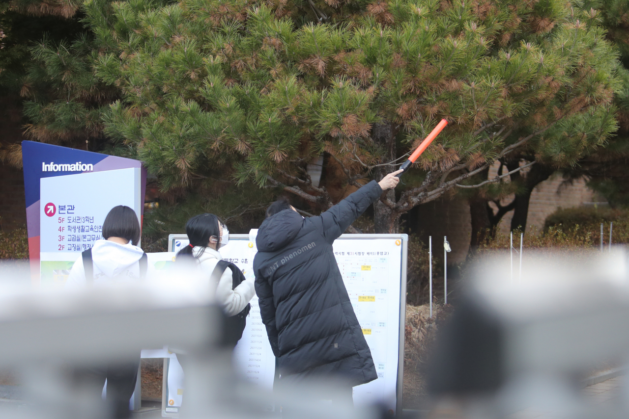 2023학년도 대학수학능력시험(수능)일인 17일 오전 고사장이 마련된 광주 서구 풍암고등학교에서 한 교직원이 수험생에게 시험장 위치를 설명해주고 있다. [연합]
