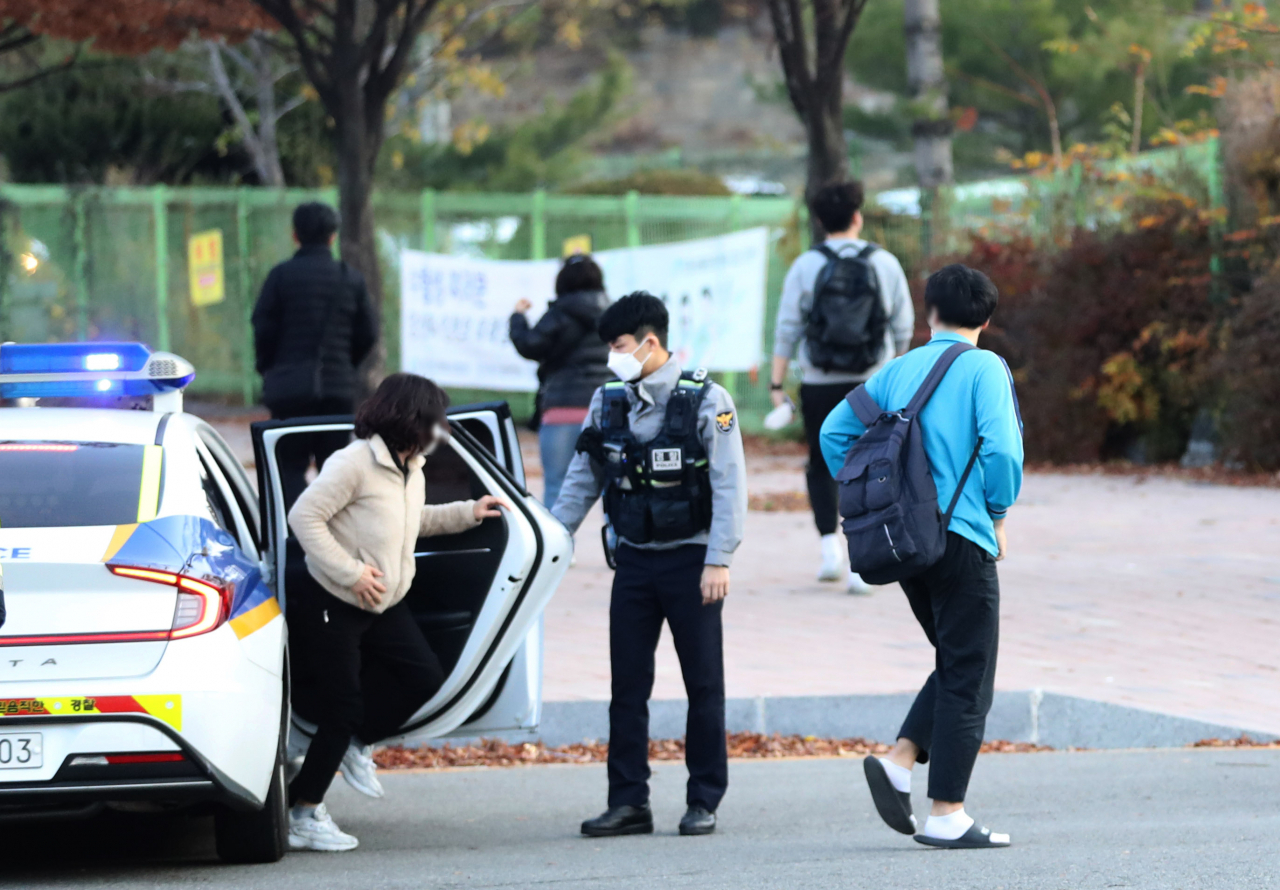 2023학년도 대학수학능력시험일인 17일 오전 인천시 미추홀구 선인고 앞에서 한 수험생과 어머니가 순찰차에서 내리고 있다. [연합]