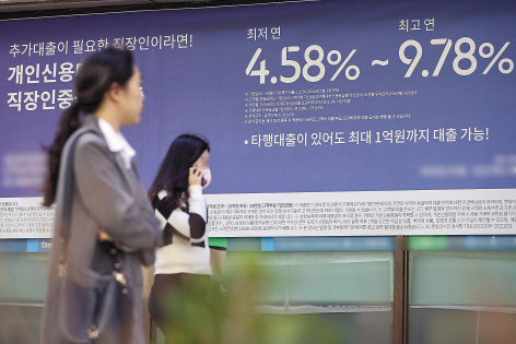 물가·고금리로 가계의 여윳돈이 사라지고 있다. 이 영향으로 정기예금은 늘고 있는데 매달 꼬박꼬박 정해진 돈을 내야 하는 정기적금은 줄어드는 것으로 파악됐다. 시민들이 서울의 한 시중은행이 내건 대출 광고 앞으로 지나고 있다. [연합]
