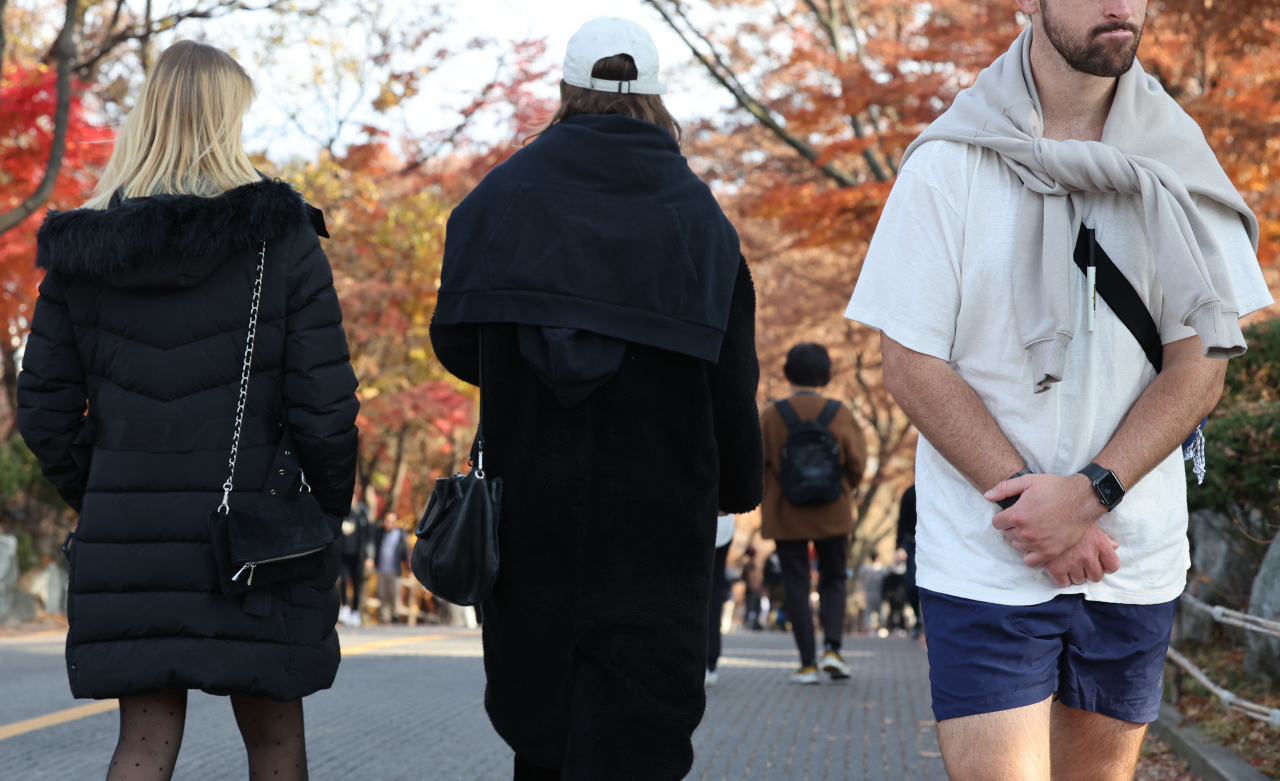 포근한 날씨를 보인 지난 20일 오후 서울 남산에서 외국인과 시민들이 단풍을 즐기고 있다. 반바지 차림도 눈에 띈다.[연합]