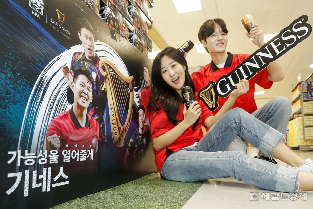 디아지오코리아의 맥주 브랜드 기네스가 대한축구협회(KFA)와 컬래버레이션 제품 ‘기네스x대한축구협회 스페셜 패키지’를 출시한 가운데 서울 광진구 이마트 자양점 기네스 부스에서 모델들이 기네스를 들고 포즈를 취하고 있다. 사진=디아지오코리아 제공