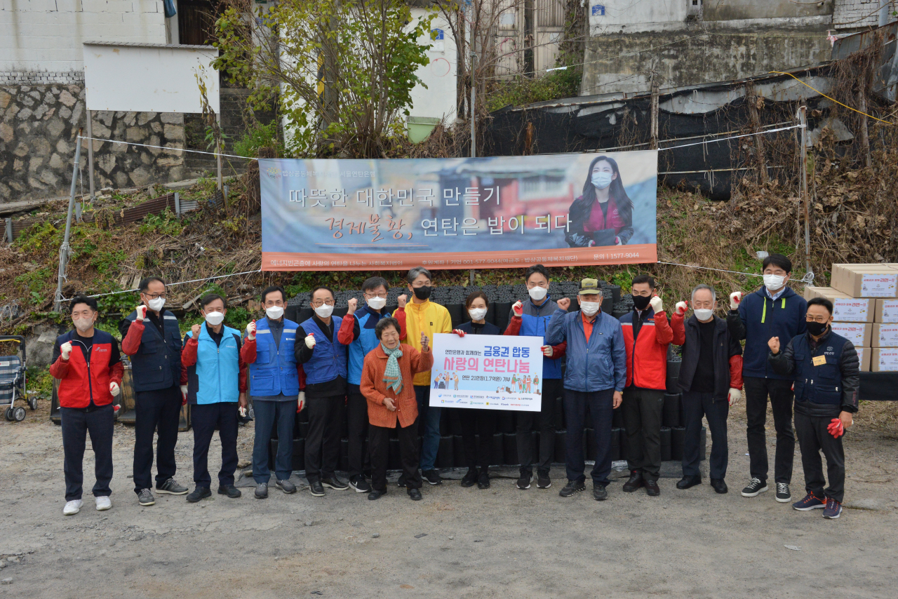 12개 금융 공공기관 및 협회, 금융회사 기관장 및 임직원들이 21일 서울 노원구 백사마을에서 에너지 취약계층에게 연탄을 직접 전달하는 봉사활동을 진행했다. 이날 참석자들이 기념촬영을 하고 있다.[서민금융진흥원 제공]