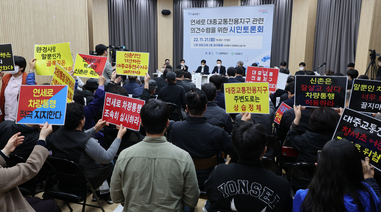 지난해 11월 21일 서울 서대문구 신촌 파랑고래에서 열린 연세로 대중교통전용지구 의견수렴 시민토론회 중 상인들이 손팻말을 들고 있다. [연합]