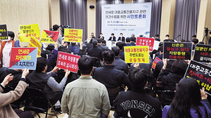21일 서울 서대문구 신촌 파랑고래에서 열린 연세로 대중교통전용지구 의견수렴 시민토론회 중 상인들이 손팻말을 들고 있다. [연합]