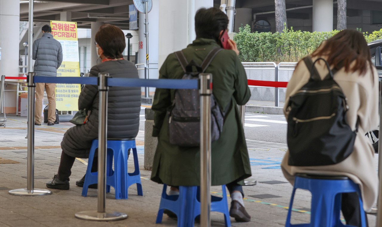 People wait in line to get tested for COVID-19 at a testing center in Seoul on Wednesday. (Yonhap)