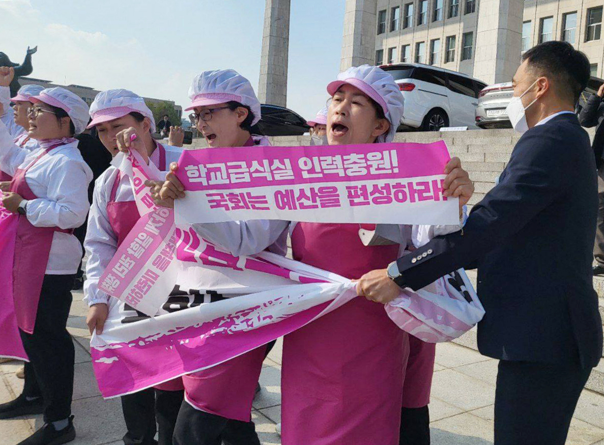 지난 8일 전국학교비정규직노동조합 급식실 조합원들이 8일 서울 영등포구 국회 본관 계단에서 기자회견을 하고 있다. [연합]