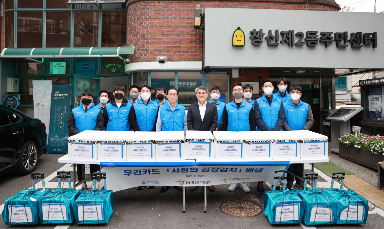 22일 창신제2동에서 진행된 '사랑의 김장김치' 기부 행사에서 김정기 우리카드 사장(앞줄 왼쪽 네 번째)과 전경표 창신2동장(왼쪽 다섯 번째), 우리카드 임직원들이 기념사진을 촬영하고 있다.[우리카드 제공]