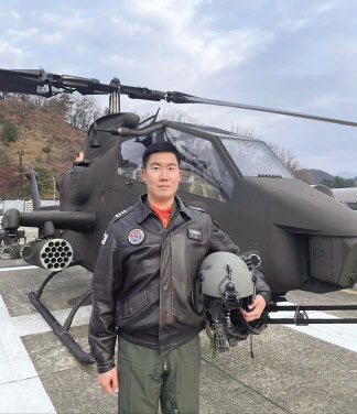 2022년 육군 ‘탑 헬리건’으로 선정돼 대통령상을 수상한 육군 103항공대대 김용진 대위가 코브라 헬기 앞에서 기념촬영을 하고 있다. [육군 제공]