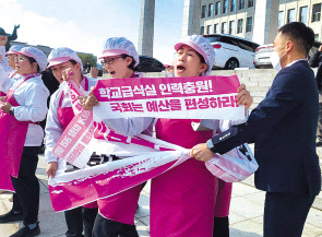 지난 8일 전국학교비정규직노동조합 급식실 조합원들이 서울 영등포구 국회 본관 계단에서 기자회견을 하고 있다. [연합]