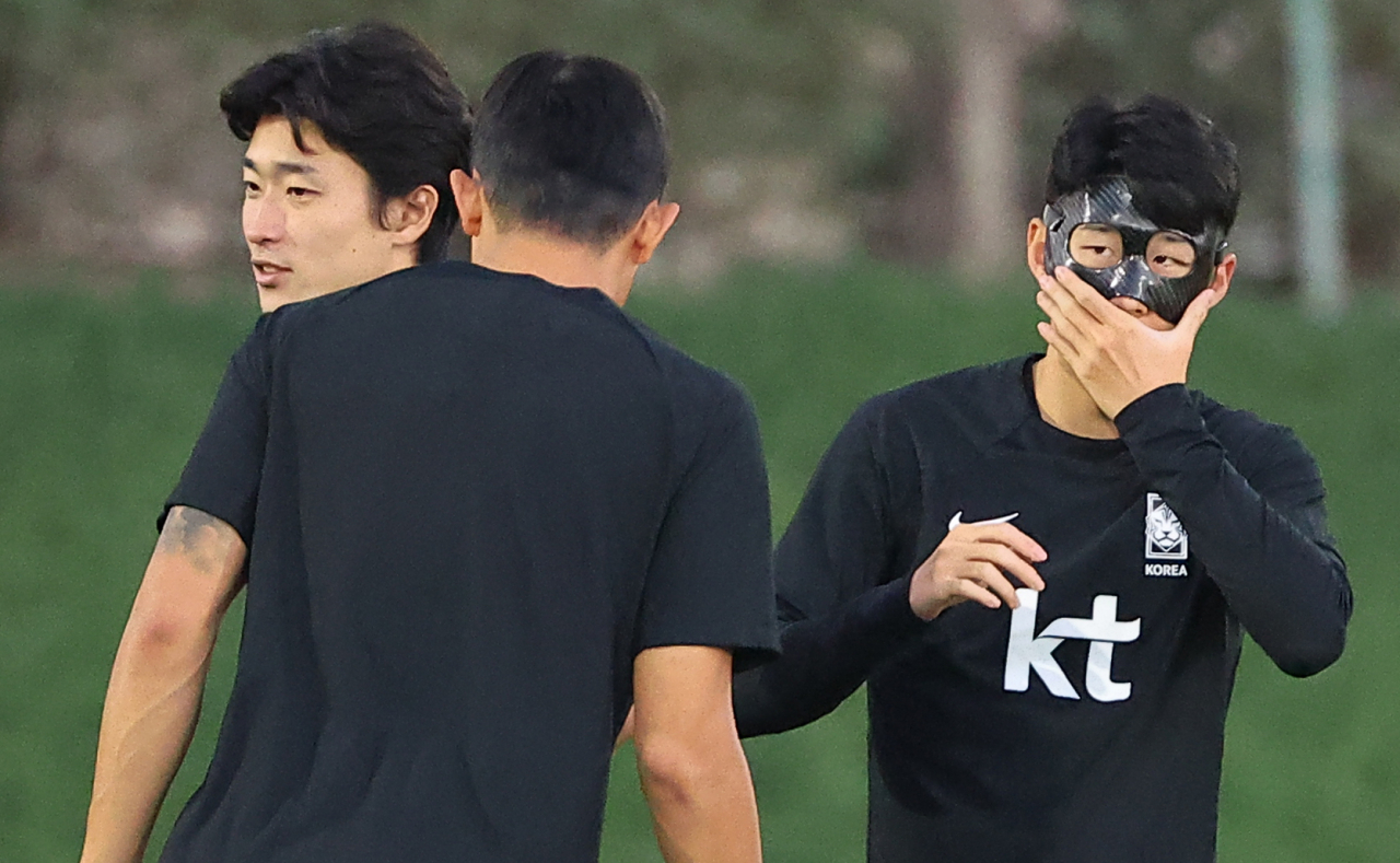 2022 카타르 월드컵 대표팀 손흥미닝 22일(현지시간) 카타르 도하 알에글라 훈련장에서 훈련 중 마스크를 만지고 있다. 왼쪽부터 조규성, 김민재, 손흥민. [연합]