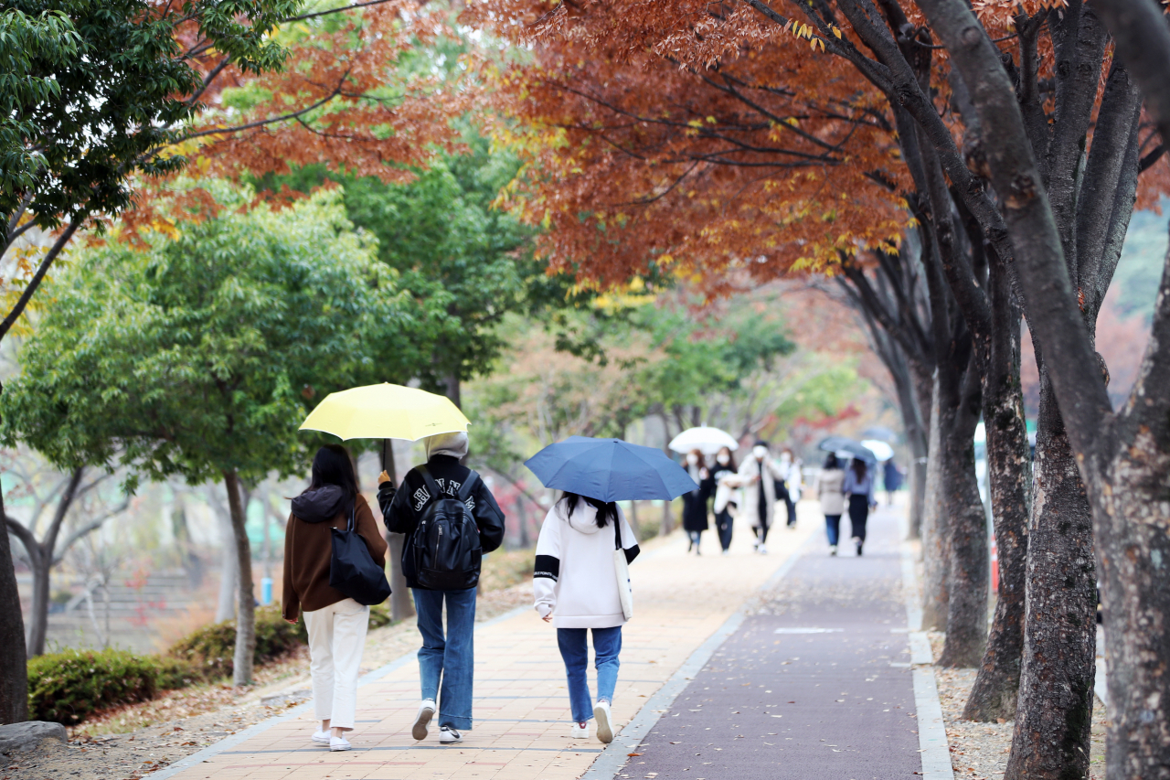 빗방울이 떨어진 지난 22일 오후 광주 북구 전남대학교 교정에서 행인들이 우산을 쓰고 걷고 있다. [연합]
