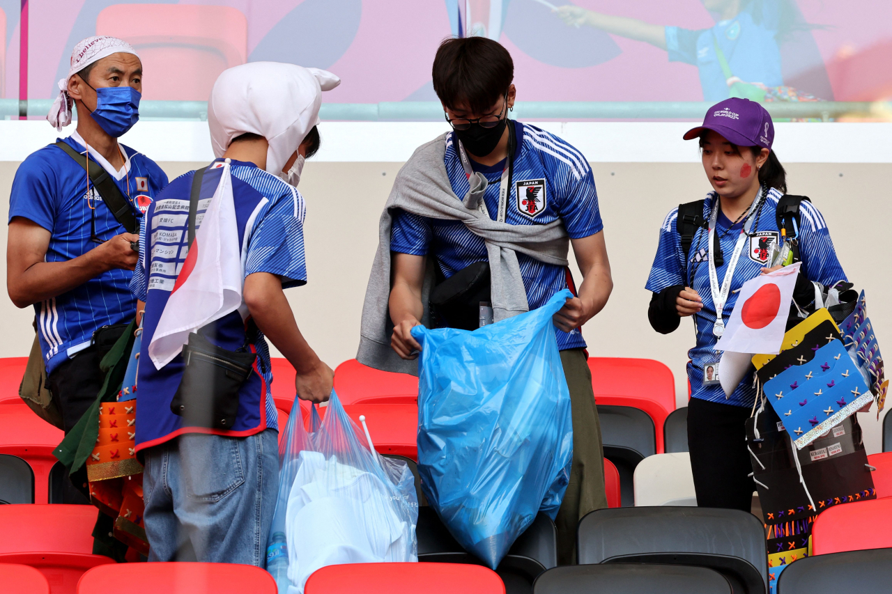 일본 축구 팬들이 27일(현지시간) 카타르 알라이얀 아흐마드 빈 알리 스타디움에서 2022 카타르 월드컵 조별리그 E조 일본과 코스타리카의 경기가 끝난 후 경기장을 청소하고 있다. 지난 23일 조별리그 1차전에서 독일에 2-1 역전승을 거뒀던 일본은 이날 코스타리카에 0-1로 패했다. [연합]