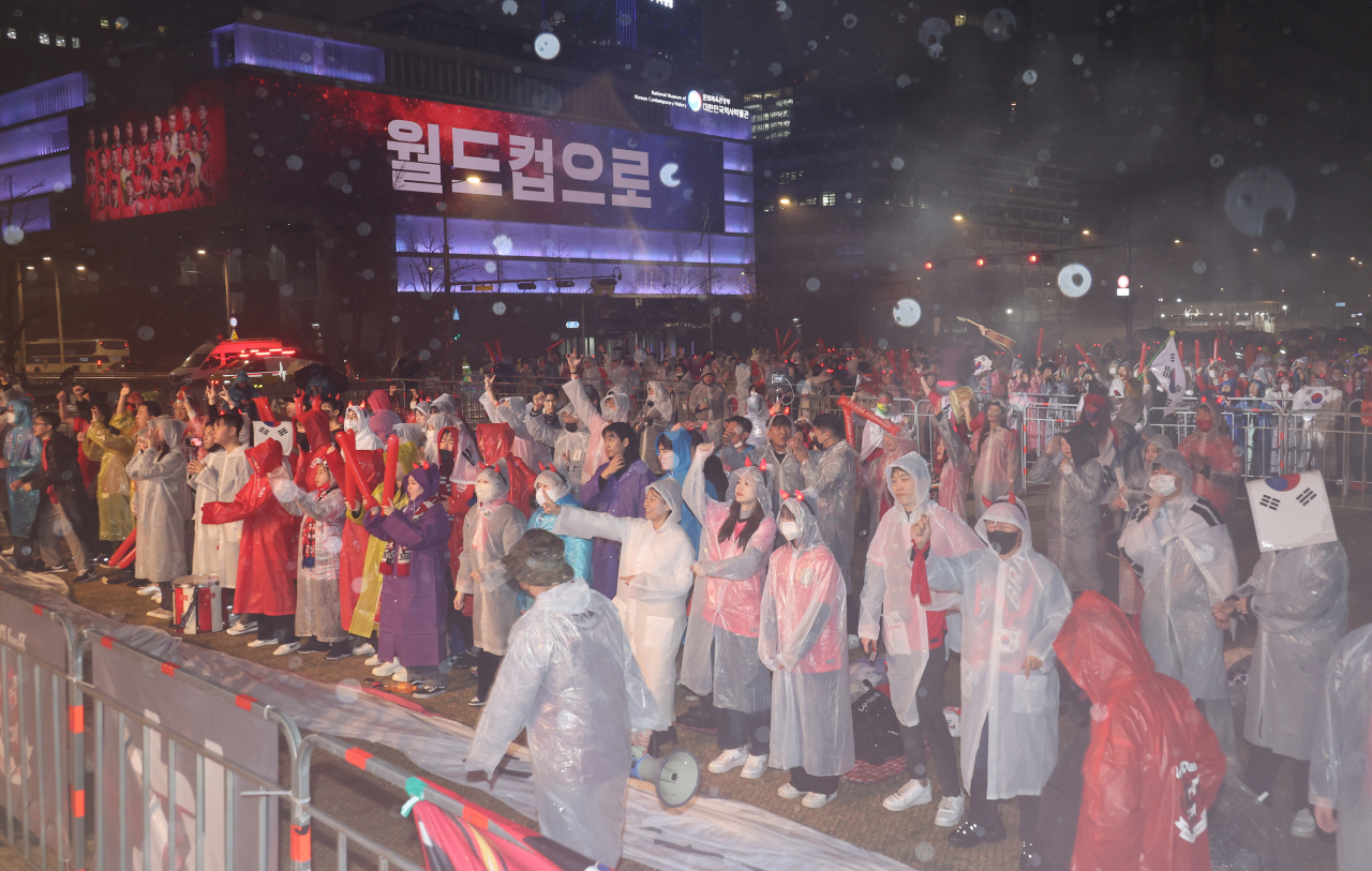28일 오후 서울 광화문광장에서 열린 2022 카타르월드컵 조별리그 H조 2차전 한국과 가나 전을 앞두고 시민들이 비가 내리는 가운데 열띤 응원전을 펼치고 있다. [연합]