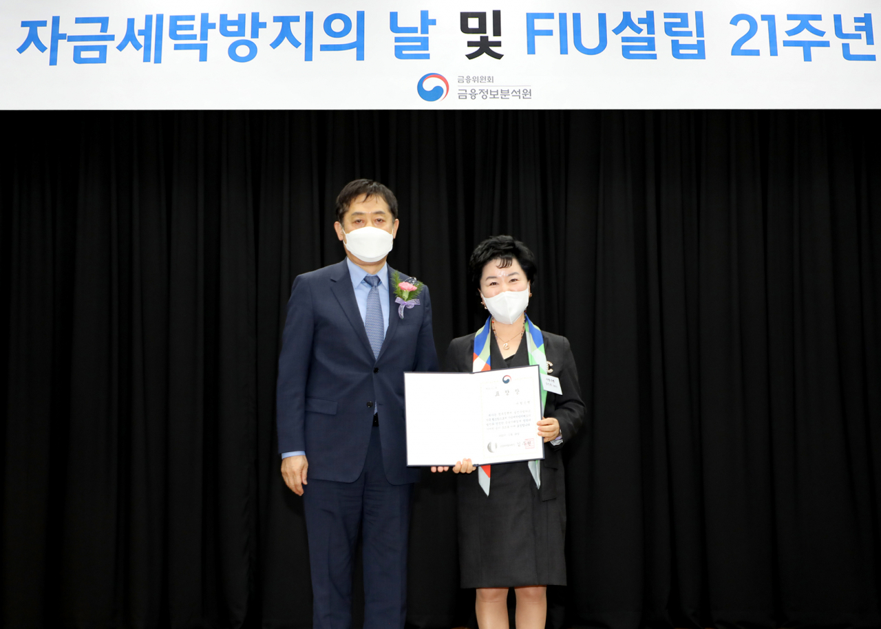 Sh수협은행은 지난 28일 서울 중구 전국은행연합회에서 열린 ‘제16회 자금세탁방지의 날’ 기념식에서 자금세탁 방지에 기여한 공로를 인정받아 금융위원장 표창을 수상했다. 강신숙 수협은행장(오른쪽)이 김주현 금융위원장으로부터 표창장을 수여받고 기념촬영을 하고 있다. [사진=수협은행]