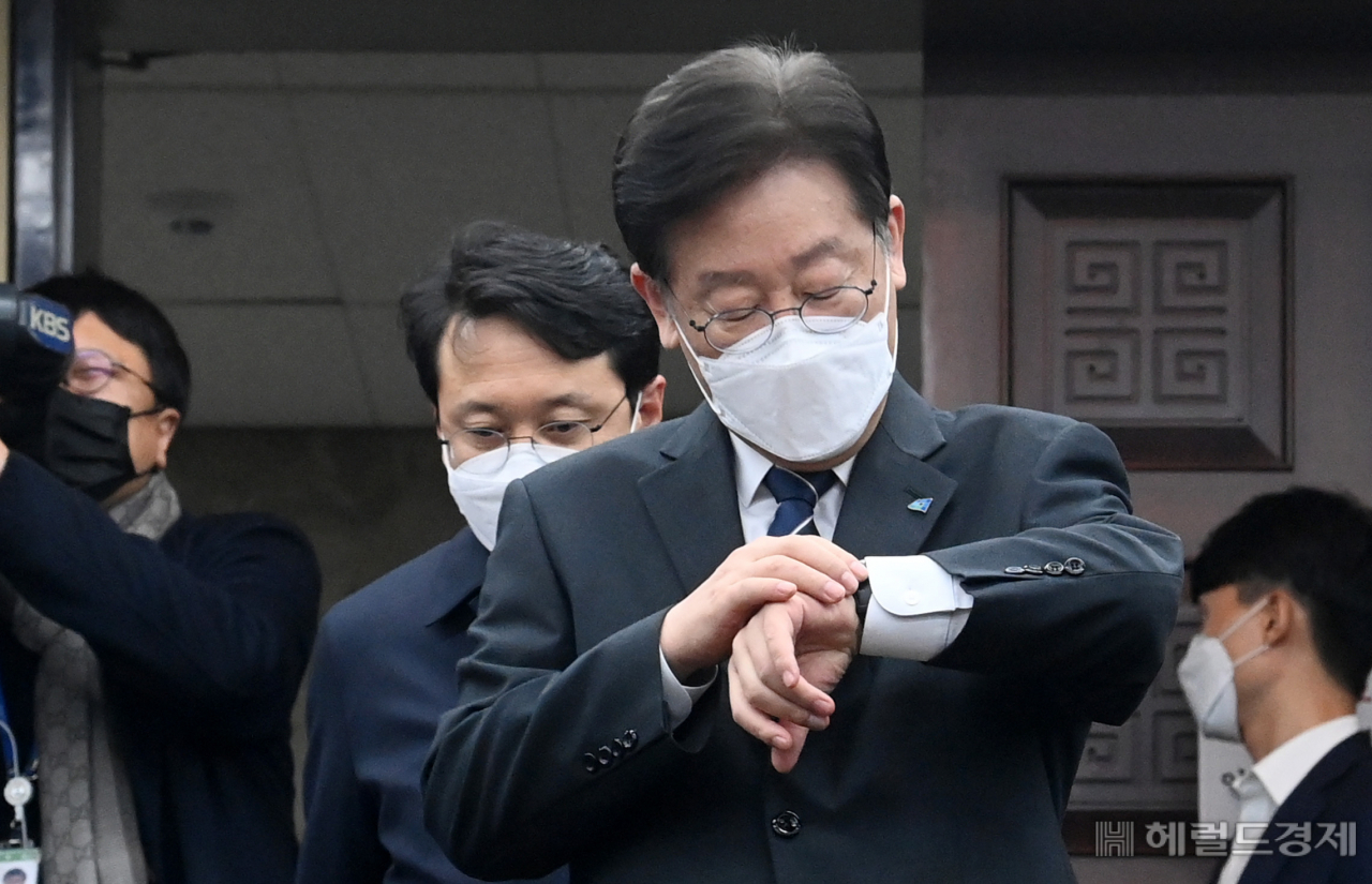 이재명 더불어민주당 대표가 29일 서울 여의도 국회에서 열린 의원총회에서 시계를 보며 입장하고 있다. 이상섭 기자
