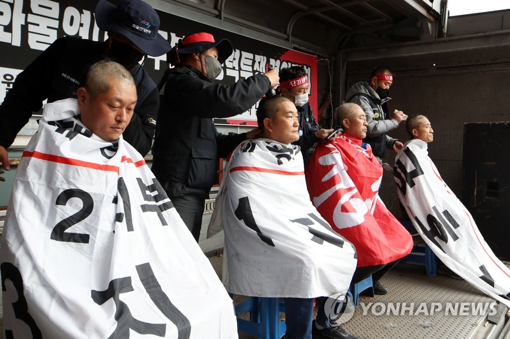 화물연대 총파업 엿새째인 29일 오후 광주 서구 기아 오토랜드 광주공장 남문 앞에서 열린 화물연대 광주본부 총력투쟁 결의대회에서 지도부가 삭발투쟁하고 있다.[연합]