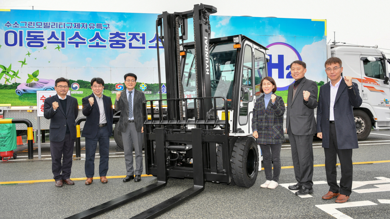 수소모빌리티 실증사업 킥오프 행사에 참석한 관계자들이 수소지게차 옆에서 기념촬영을 하고 있다. (왼쪽부터) 김기철 현대글로비스 상무, 금영범 현대모비스 상무, 우항수 울산테크노파크 단장, 김미금 중소벤처기업부 사무관, 인정석 울산광역시 사무관, 이재훈 현대제뉴인 상무. [사진=현대모비스 제공]