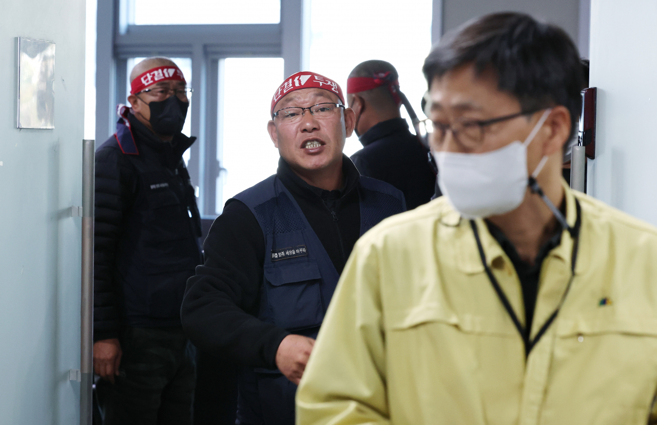 Ministry of Land, Infrastructure and Transport Director Koo Heon-sang walks out of meeting room in Sejong City, while Cargo Truckers Solidarity rep. Kim Tae-young shouts in protest. Second talk to resolve issue over minimum freight rate policy failed again on Wednesday. (Yonhap)