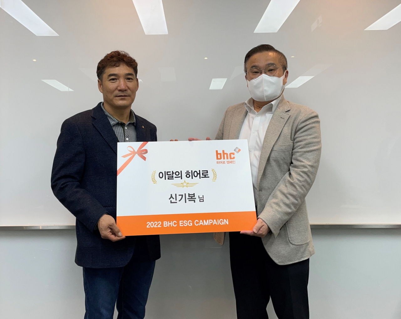 bhc그룹 SP/직영사업부 고병환 상무(우측)가 지난 28일 ‘bhc 히어로’로 선정된 신기복 씨(좌측)를 만나 상장과 치킨 상품권을 전했다. [bhc 제공]