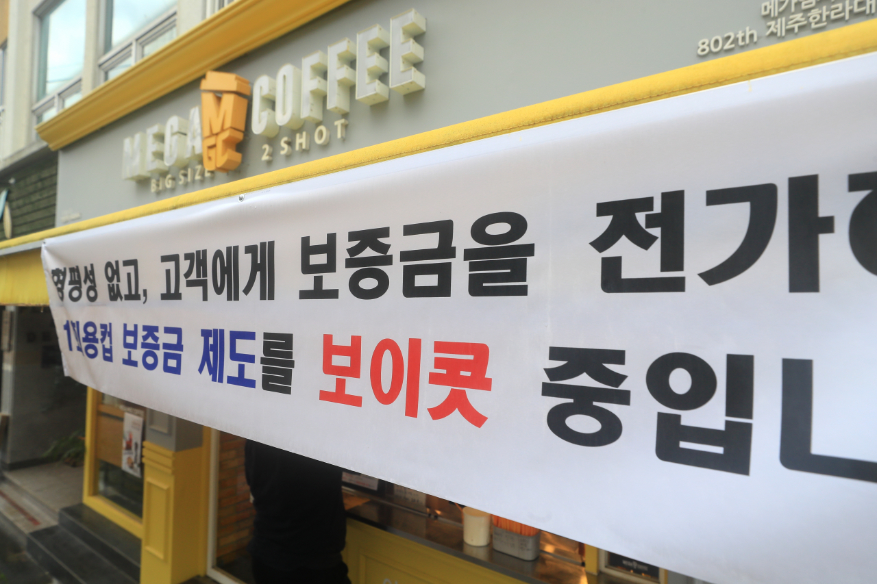 전국에서 처음으로 제주도 내 일부 프랜차이즈 매장을 대상으로 일회용컵 보증금제도가 실시된 2일 오전 제주시 연동의 한 프랜차이즈 카페에 보증금제도를 보이콧한다는 현수막이 걸려 있다. [연합]