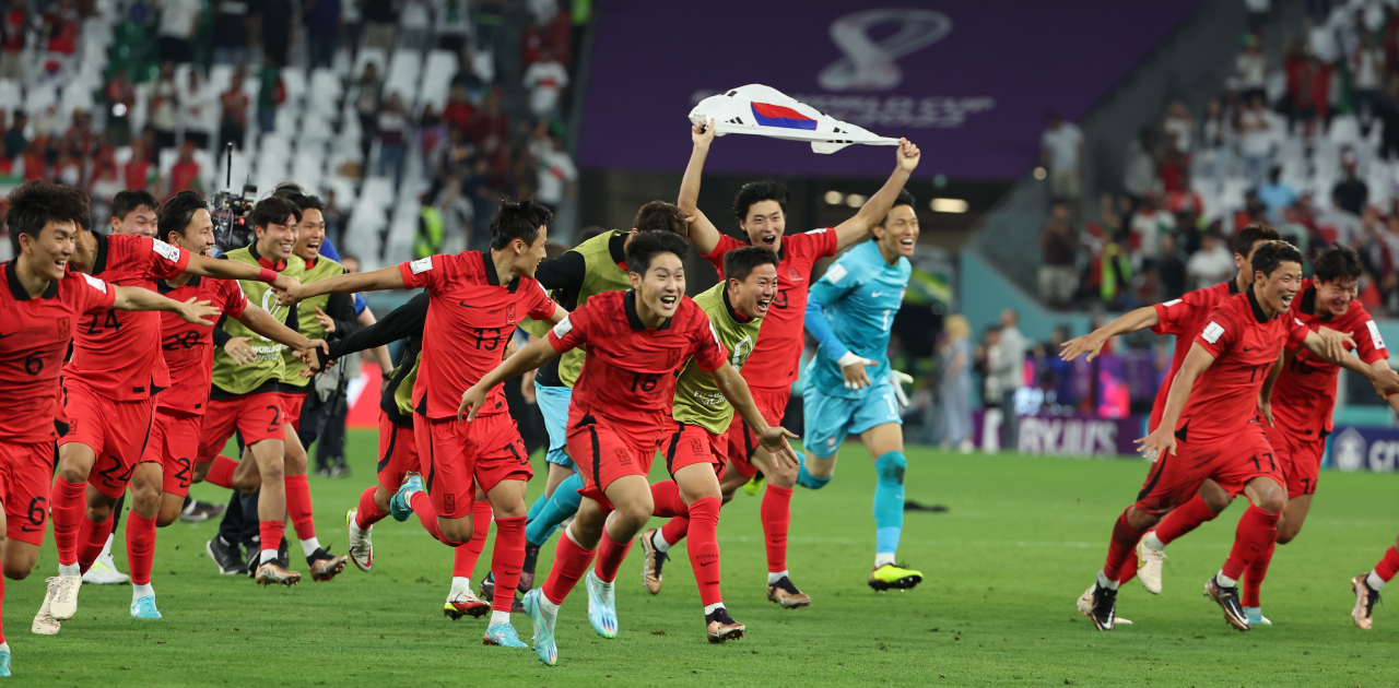 3일 오전(한국시간) 카타르 알라이얀의 에듀케이션 시티 스타디움에서 열린 2022 카타르 월드컵 조별리그 H조 3차전 대한민국과 포르투갈 경기에서 승리를 거두며 16강 진출에 성공한 대표팀 황희찬, 조규성 등 선수들이 태극기와 함께 그라운드를 달리며 기쁨을 만끽하고 있다. [연합]