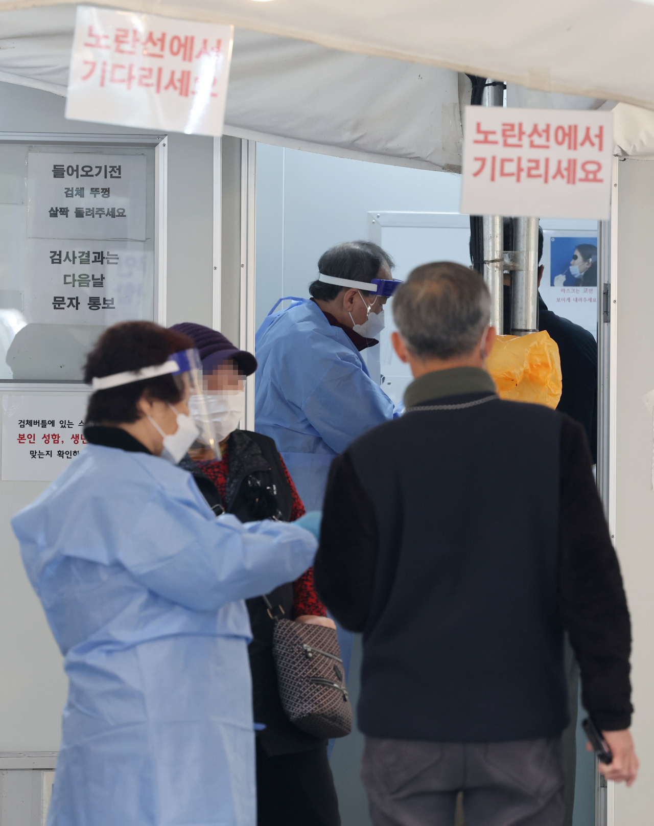 서울 노원구보건소 코로나19 선별진료소를 찾은 시민들이 의료진의 안내를 받고 있다. [연합]