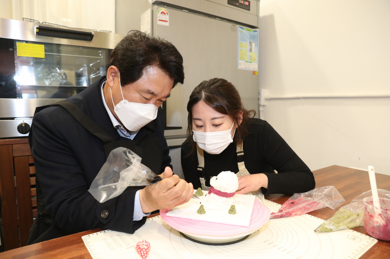 ‘쁜이네 곳간’을 찾아 애견용 간식을 직접 만들어보고 있는 박준희 관악구청장(왼쪽). [관악구 제공]