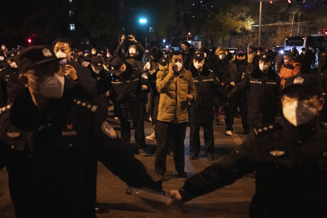 지난달 27일 중국 베이징에서 코로나19 봉쇄 정책에 항의하는 시위가 벌어지자 경찰이 통제에 나선 모습. 지난달 24일 신장 우루무치에서 화재로 10여명이 숨진 사건의 원인이 봉쇄 설치물 때문이란 의혹이 커지가 베이징에선 '백지 시위'가 벌어졌다. [AP]