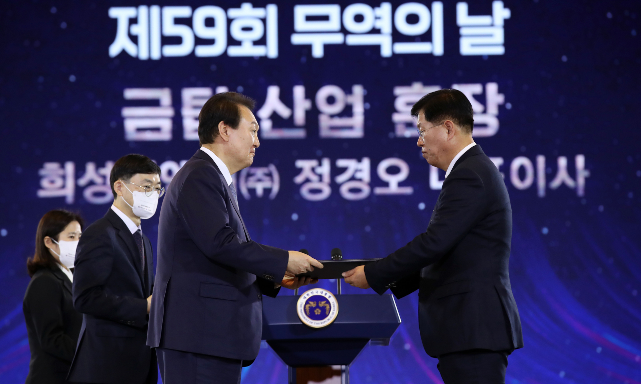 윤석열 대통령이 5일 서울 삼성동 코엑스에서 열린 제59회 무역의날 기념식에서 정경오 희성피엠텍 대표에게 금탑산업훈장을 수여하고 있다. [연합]