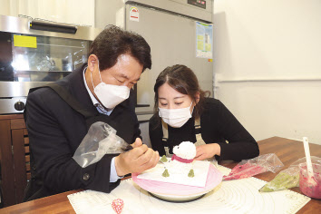 ‘쁜이네 곳간’을 찾아 애견용 간식을 직접 만들어보고 있는 박준희(왼쪽) 관악구청장.[관악구 제공]