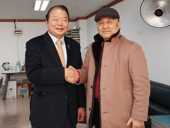 신한용 전 인천테니스 협회장(왼쪽)과 이인철 전 인천생활체육회장이 후보 단일화를 이룬 뒤 악수를 나누고 있다.