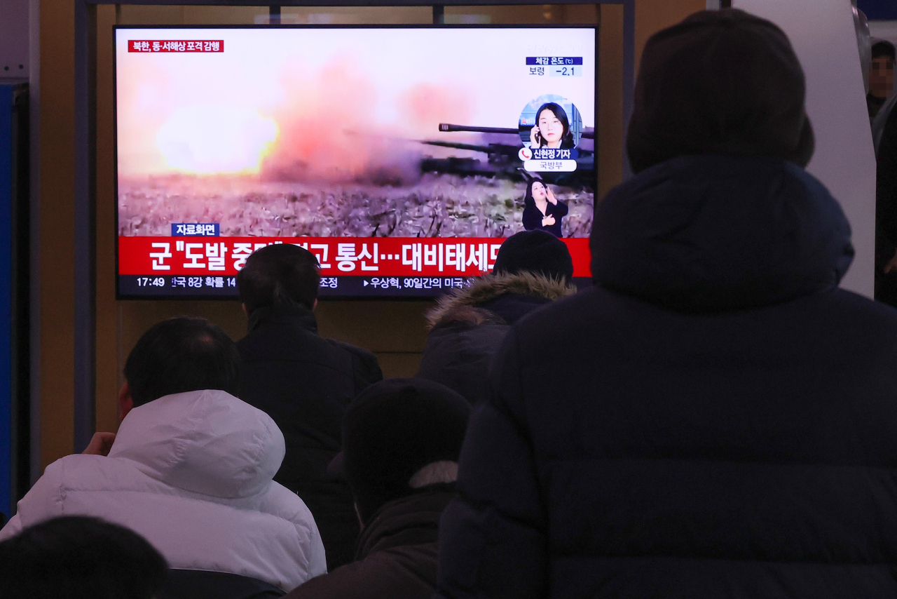 People watch a TV report at Seoul Station on Monday about North Korea's firing of artillery shots overnight into maritime buffer zones near the inter-Korean border. (Yonhap)