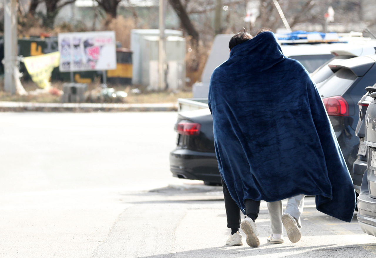 영서 내륙과 산지를 중심으로 한파특보가 발효 중인 지난 4일 강원 인제군 북면 용대리에서 담요를 두른 채 발걸음을 옮기고 있는 관광객들. [연합]