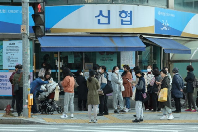 지난 10월 27일 연 10%짜리 특판 적금을 판매하는 서울 관악신협 앞에 몰린 시민들. 지난 24일 한국은행이 기준금리를 올렸지만 금융 당국의 수신금리 경쟁 자제 요청에 따라 이번에는 파격적인 예·적금 금리를 내놓는 은행이 드물어졌다. [연합]