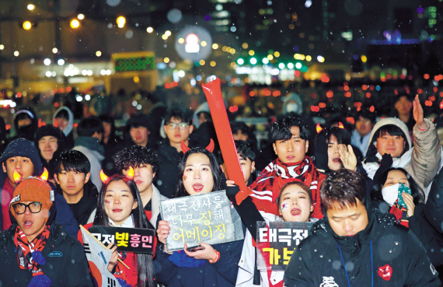 2022 카타르 월드컵 16강전 한국과 브라질의 경기가 열린 서울 종로구 광화문 광장에 조명뿔, 메이크업과 피켓, 응원봉으로 무장한 붉은 악마들이 열띤 응원을 하고 있다. [연합]