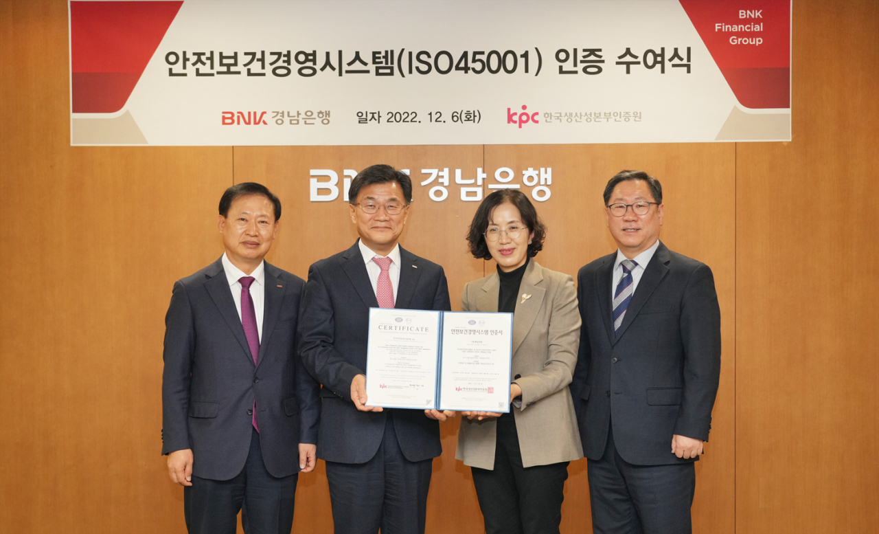 BNK경남은행 최홍영 은행장(사진 왼쪽 두번째)이 한국생산성본부인증원 오경희 원장(사진 왼쪽 세번째)으로부터 안전보건경영시스템(ISO45001) 인증서를 전달 받고 있다. [BNK경남은행 제공]