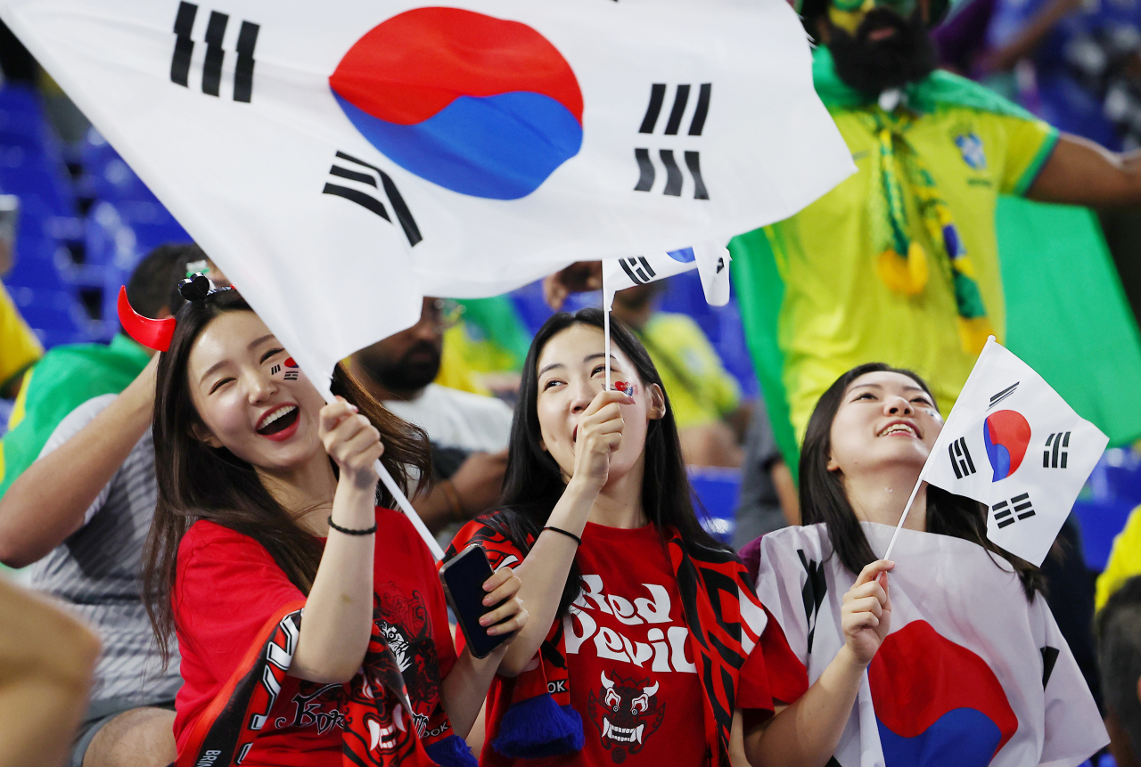 6일(한국시간) 카타르 도하 974스타디움에서 열린 2022 카타르 월드컵 16강전 대한민국과 브라질의 경기를 찾은 축구팬들이 태극기를 흔들며 응원을 하고 있다. [연합]