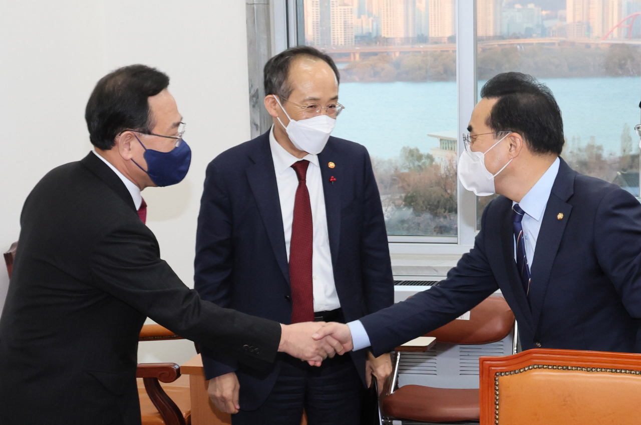 주호영 국민의힘 원내대표와 박홍근 더불어민주당 원내대표가 7일 오후 국회 예산결산특별위원회 소회의실에서 예산안 협상 전 악수하고 있다. 가운데는 추경호 부총리 겸 기획재정부 장관. [연합]