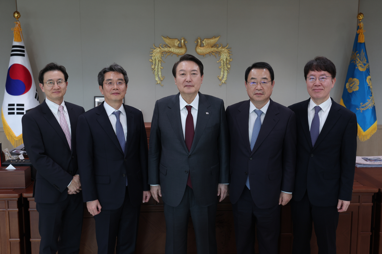 윤석열 대통령이 지난 7일 서울 용산 대통령실 청사에서 한국법학교수회 임원진과 간담회를 한 뒤 정영환 회장 등과 기념촬영을 하고 있다. 왼쪽부터 이계정 이사(서울대 법학전문대학원 교수), 조홍식 현 수석부회장 겸 차기 회장(서울대 법학전문대학원 교수), 윤 대통령, 정영환 회장(고려대 법학전문대학원 교수), 김진각 자문위원(성신여대 문화예술경영학과 교수). [연합]