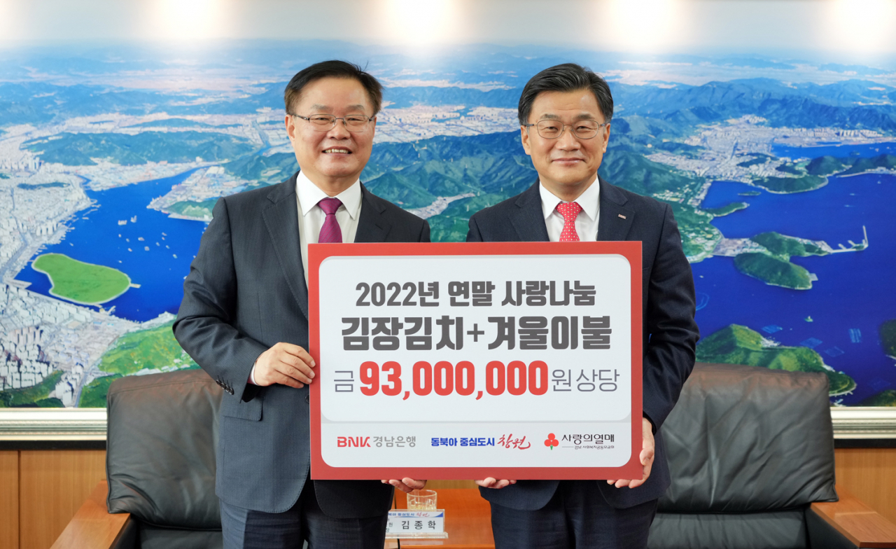 BNK경남은행 최홍영 은행장(사진 오른쪽)이 창원특례시 홍남표 시장에게 ‘김장 김치와 겨울 이불 기탁 증서’를 전달하고 있다. [BNK경남은행 제공]