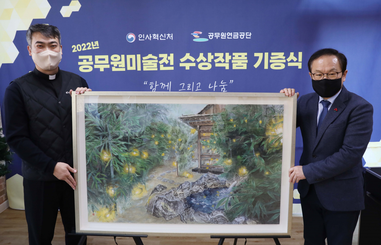 김승호 인사혁신처장(오른쪽)이 8일 세종시 전의면 세종장애인주간보호센터에서 열린 ‘2022년 공무원미술전 수상작품 기증식’에서 변창수 센터장에게 수상작품을 전달한 후 기념촬영을 하고 있다. [인사혁신처 제공]
