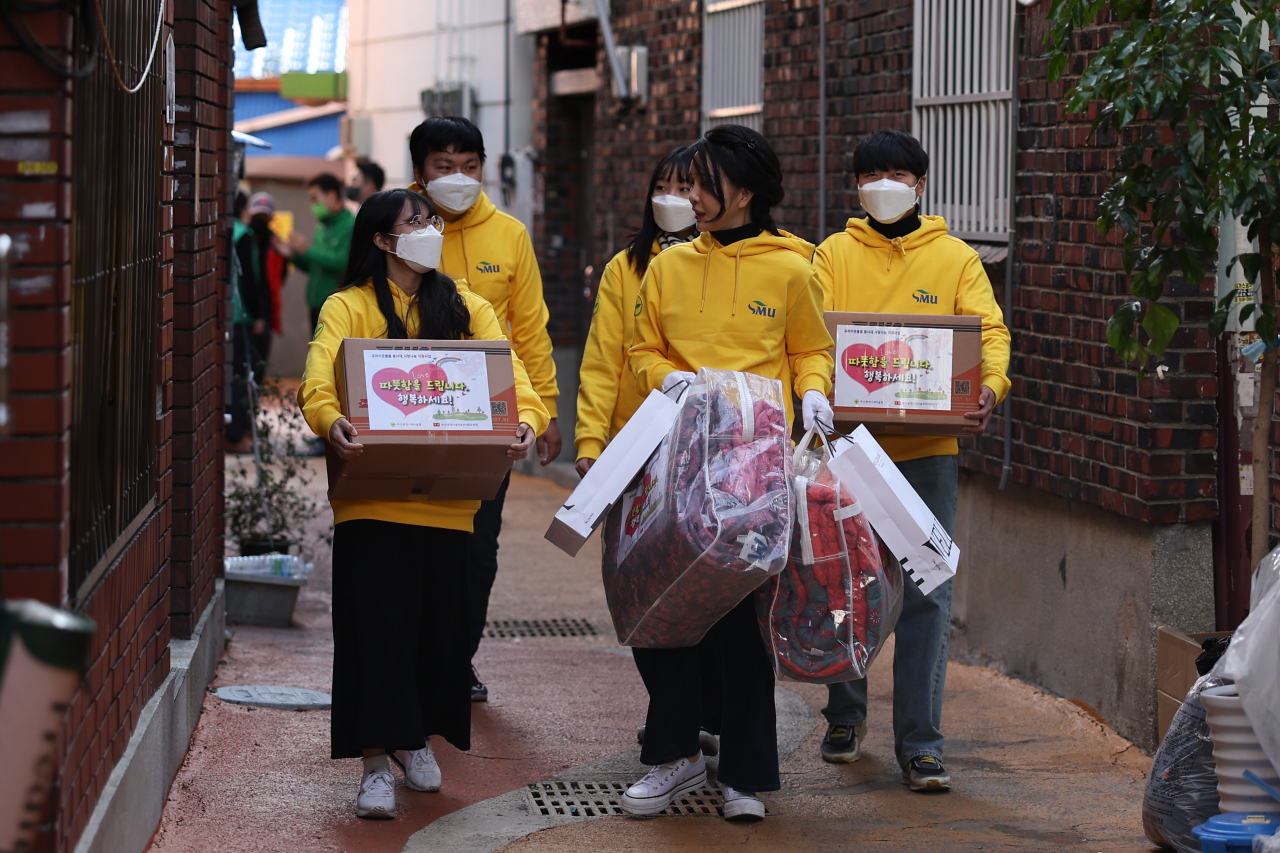 김건희 여사가 8일 부산 부산진구 새마을운동부산진구지회를 방문, 대학생 봉사자 등과 함께 쪽방촌에 전달할 생필품을 포장한 뒤 쪽방촌에 전달하고 있다. [연합]