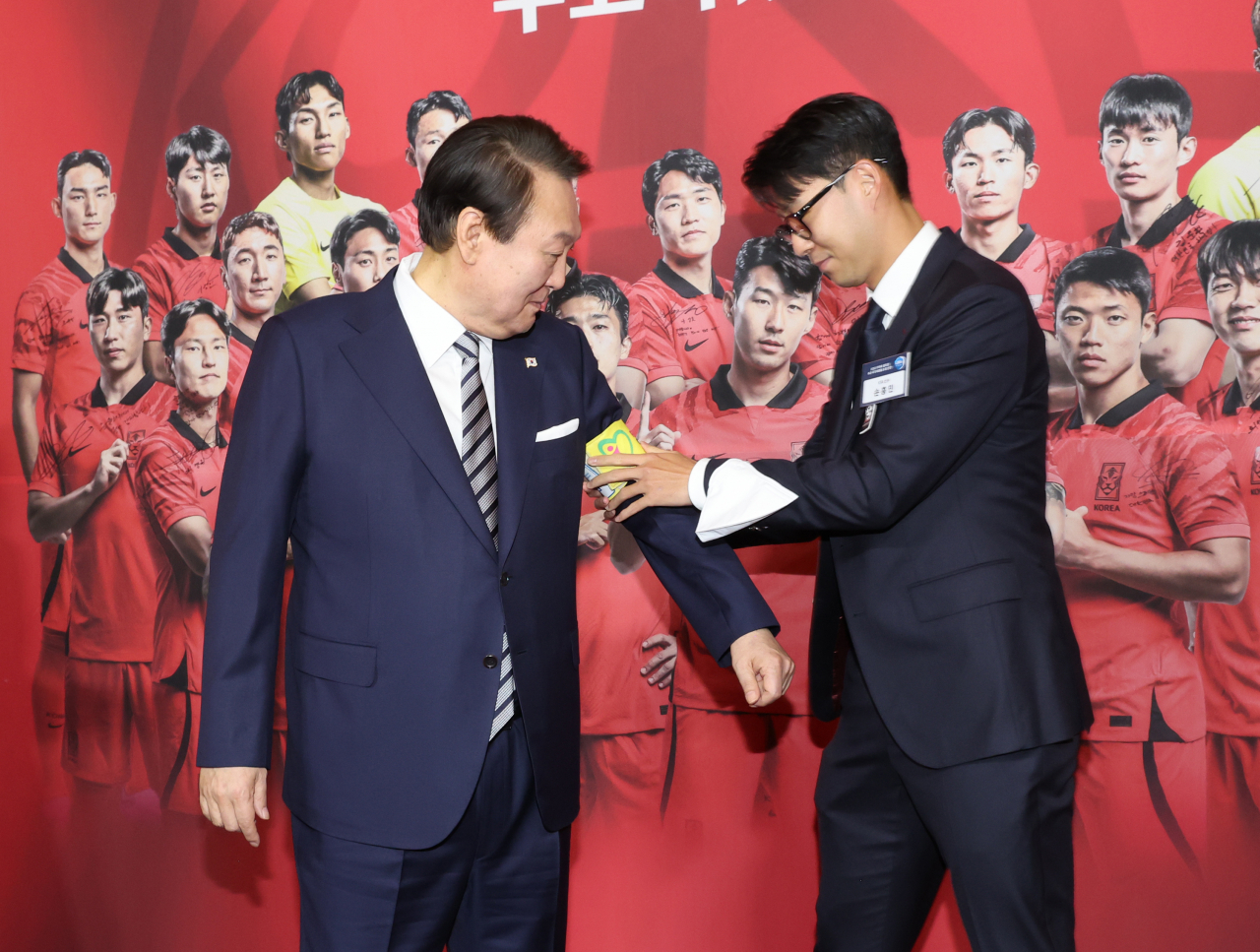 8일 청와대 영빈관에서 열린 축구 국가대표팀 환영 만찬에서 주장 손흥민 선수가 2022 카타르 월드컵 기간 착용했던 주장 완장을 윤석열 대통령에게 채워주고 있다. [연합]