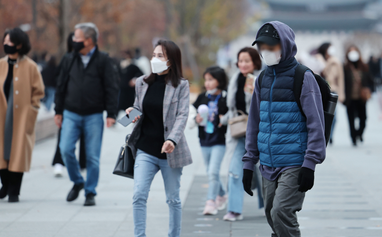 지난달 13일 오후 서울 광화문광장에서 두툼한 옷을 입은 시민들이 길을 걷고 있다. [연합]