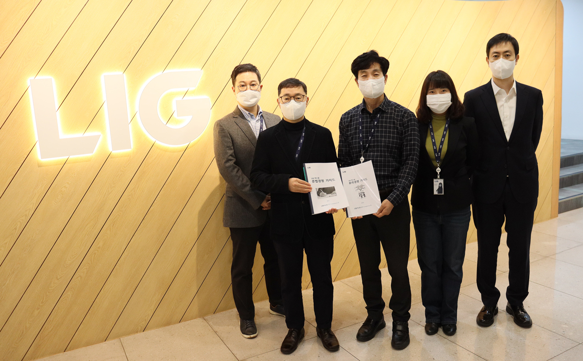 LIG넥스원 판교R&D 센터에서 법무 컴플라이언스팀 관계자들이 개정된 ‘윤리·준법경영 가이드’를 들고 기념사진을 촬영하고 있다. [LIG넥스원 제공]