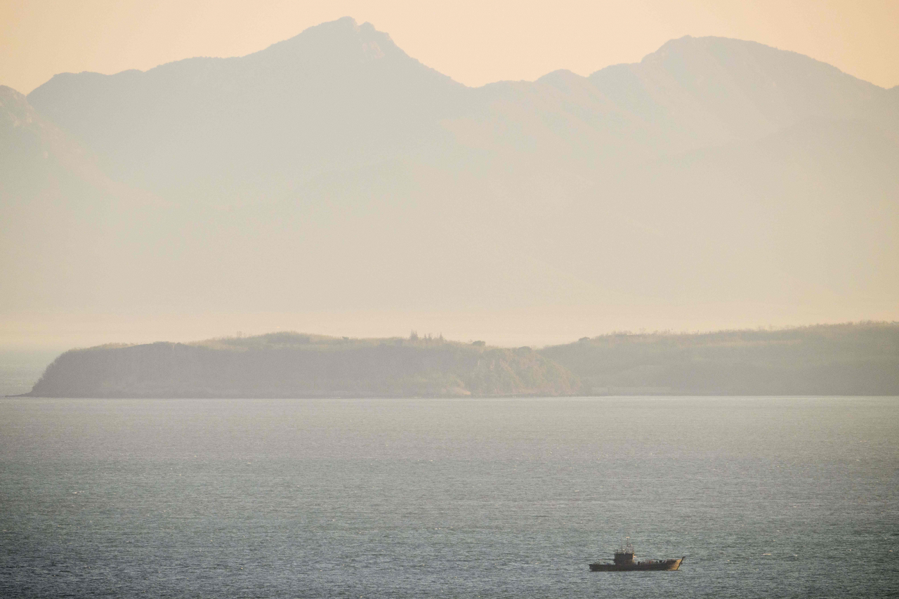 In this picture taken on Oct. 28, a fishing vessel is seen in North Korean waters near North Korea's mainland, as photographed from a viewing point on Baekryeong Island, located two kilometres from the de facto maritime border and just 14 kilometres from the North Korean mainland. Far closer to the North Korean mainland than it is to the South, Baekryeong is a fortress: tanks are parked at the sides of roads, there are guard posts on every hill, and the picturesque beaches are covered in "dragon's teeth" fortifications to deter invasion. (AFP-Yonhap)