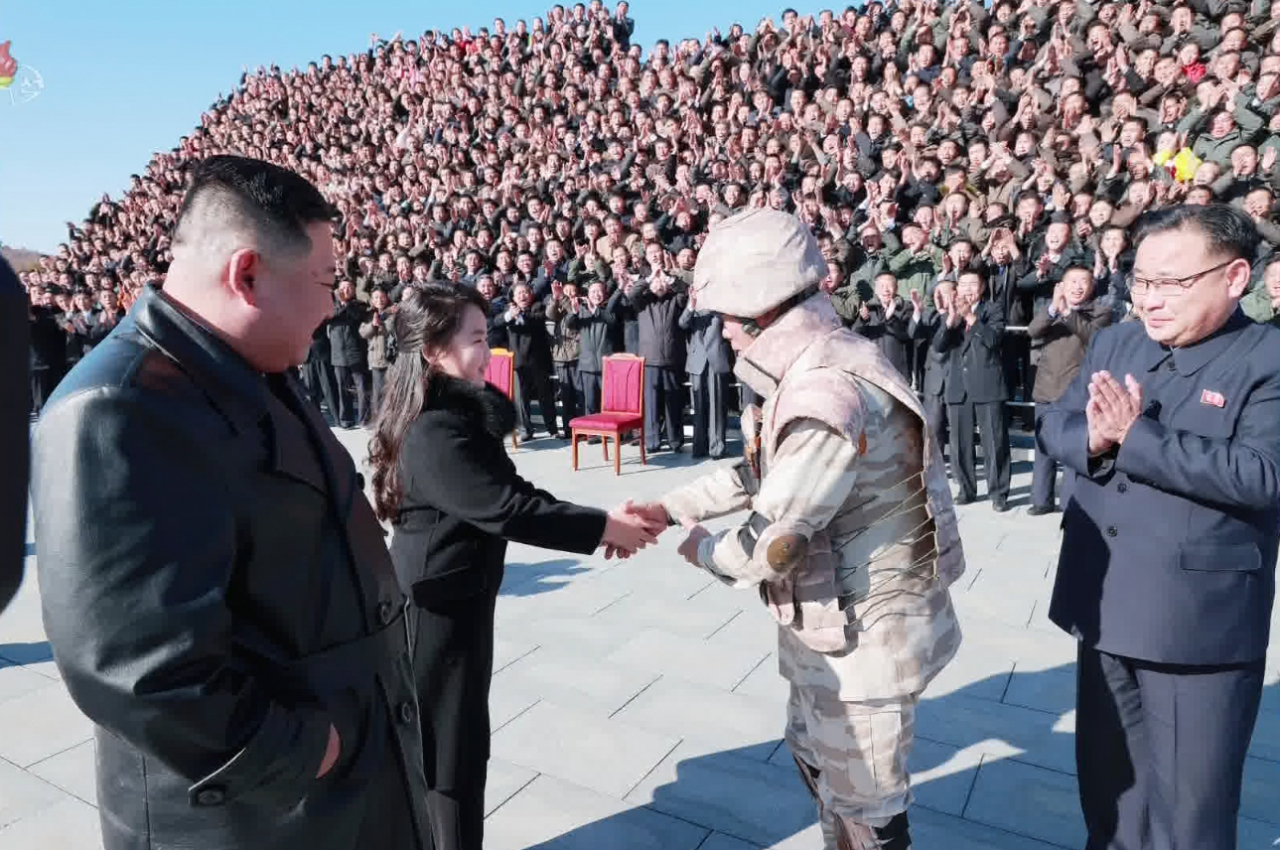 대륙간탄도미사일(ICBM) 화성-17형 발사에 참여한 공로자들과 김정은 국무위원장의 모습.[연합]
