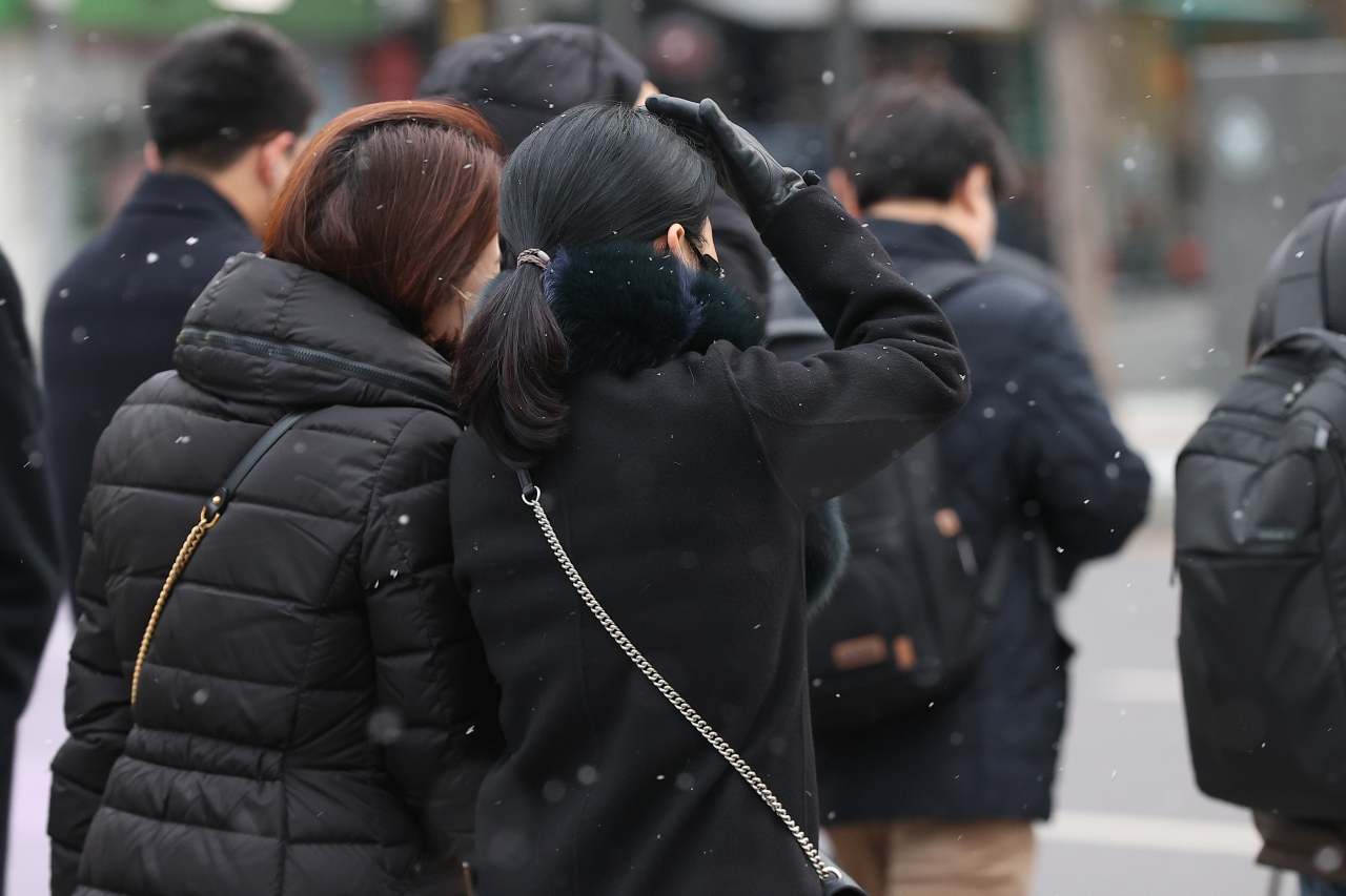 서울 등 수도권과 충청을 중심으로 눈이 내린 6일 오전 서울 광화문네거리에서 시민들이 횡단보도를 건너고 있다. 연합뉴스