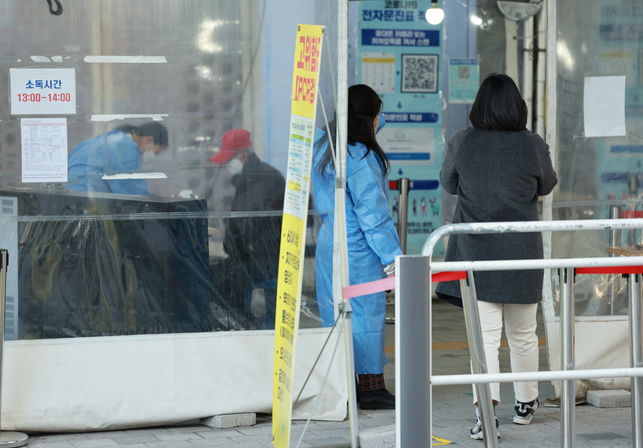 코로나19 선별검사소를 찾은 시민들이 검사를 받기 위해 문진표를 작성하고 있다. 연합뉴스
