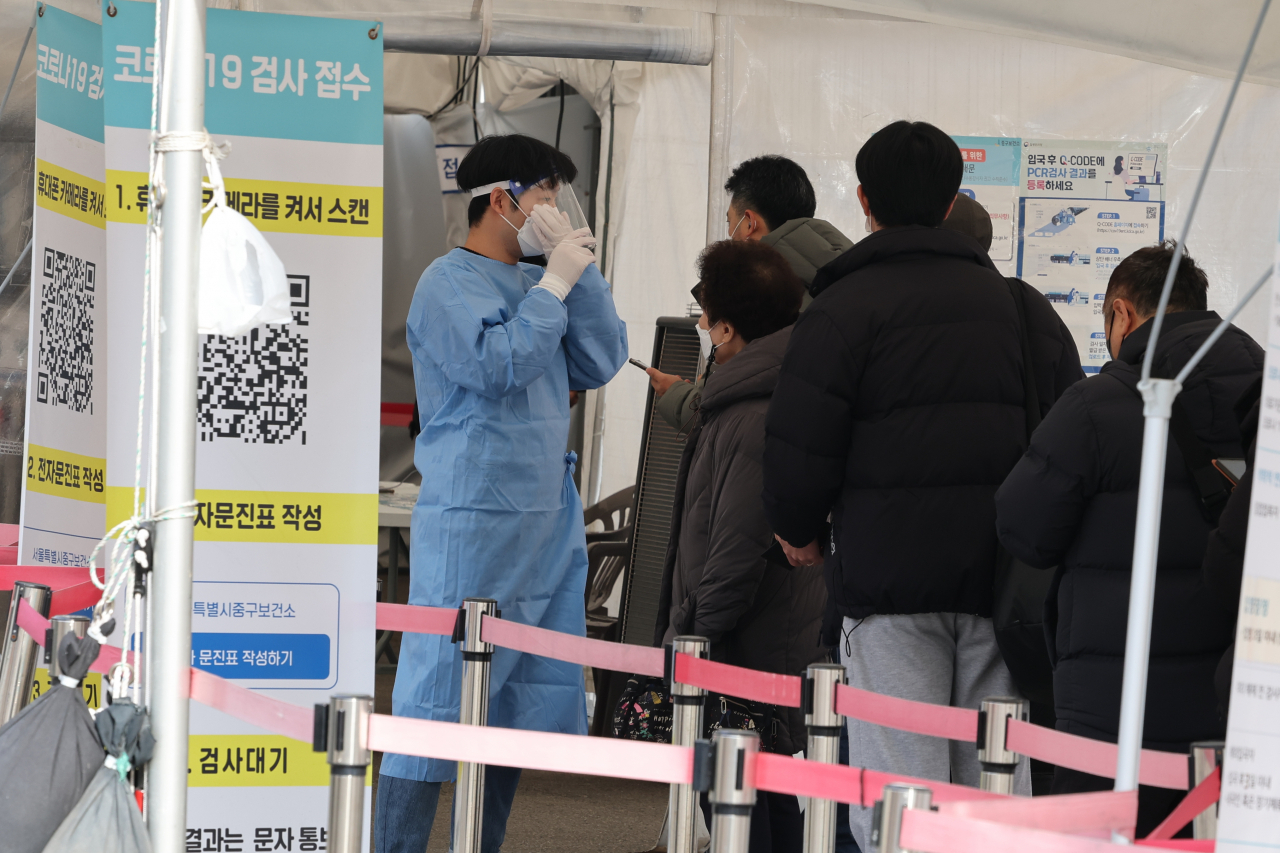 코로나19 신규 확진자가 늘어나는 가운데 12일 오후 서울 중구 서울역 임시 선별검사소에서 시민들이 검사를 받기 위해 순서를 기다리고 있다. [연합]